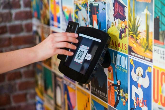 A person using their phone to scan a QR code. Illustration photo by Pexels