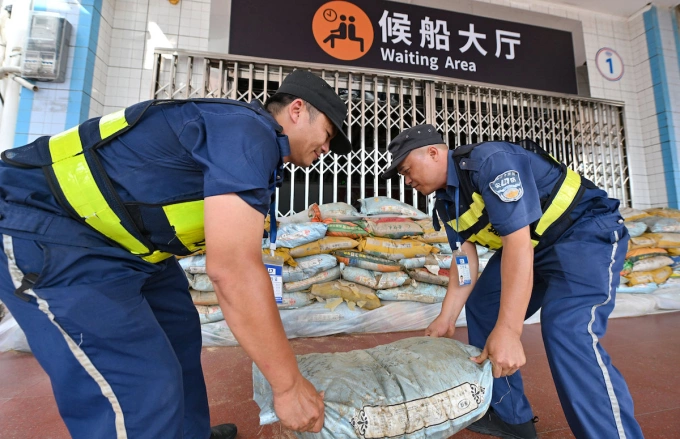 Zaměstnanci položili pytle s pískem mimo čekárnu v přístavu Xiuying v provincii Haikou, provincie Jižní Chinan, 4. října 2025, jak se blíží Typhoon Matmo. Foto od Xinhua přes AFP