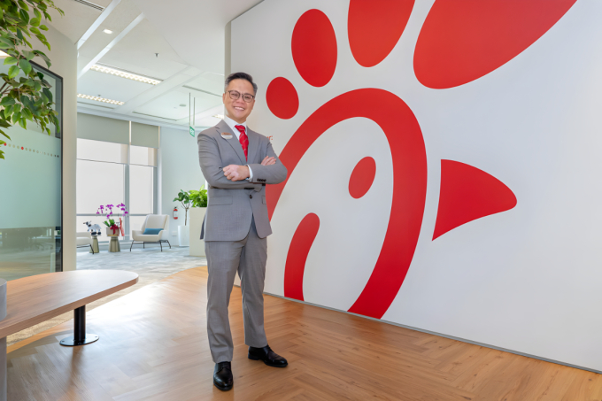 Chyn Koh poses for a photo in front of the Chick-fil-A logo. Photo courtesy of Chick-fil-A