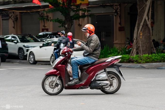 A person uses a phone while driving a motorbike in Hanoi, October 2025. Photo by VnExpress/Minh Quan