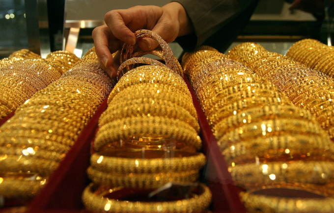 An employee checks gold bracelets at a jewelry store in Singapore April 18, 2006. Photo by Reuters