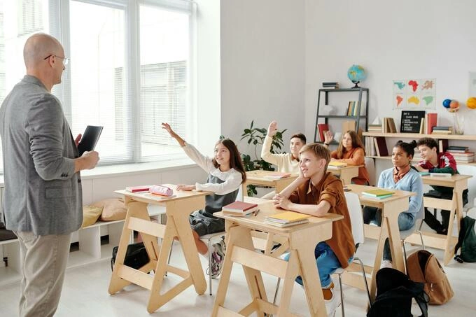 A teacher and students in a classroom. Photo from Pexels