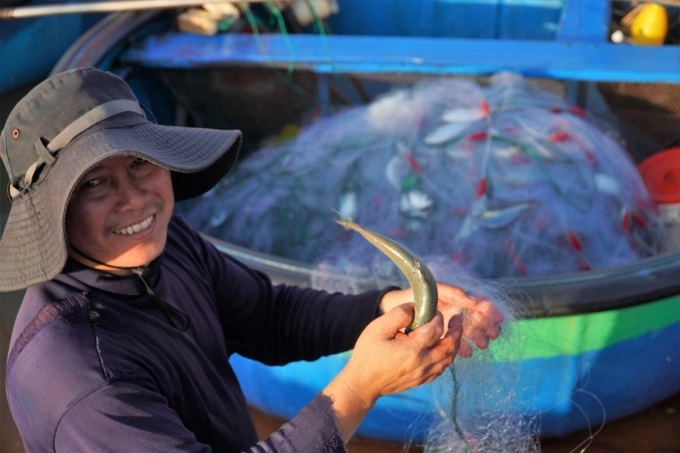 A fisherman holds a fish in Binh Thuan in March 2020. Photo by VnExpress/Viet Quoc
