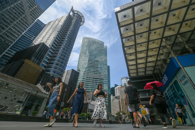 People walk out for a lunch break in the Raffles Place financial business district in Singapore on August 13, 2024. Photo by AFP
