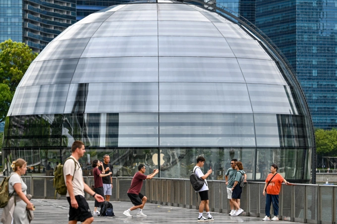 People take pictures on the boardwalk in front of the Apple Store at Marina Bay in Singapore on September 26, 2024. Photo by AFP