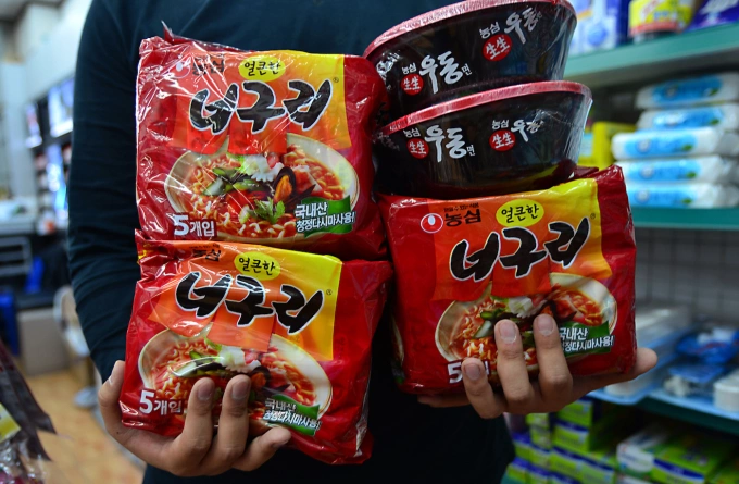 A South Korean store employee holds Nongshim brand Korean instant noodles in Seoul, South Korea. Photo by ZUMA Press Wire via Reuters