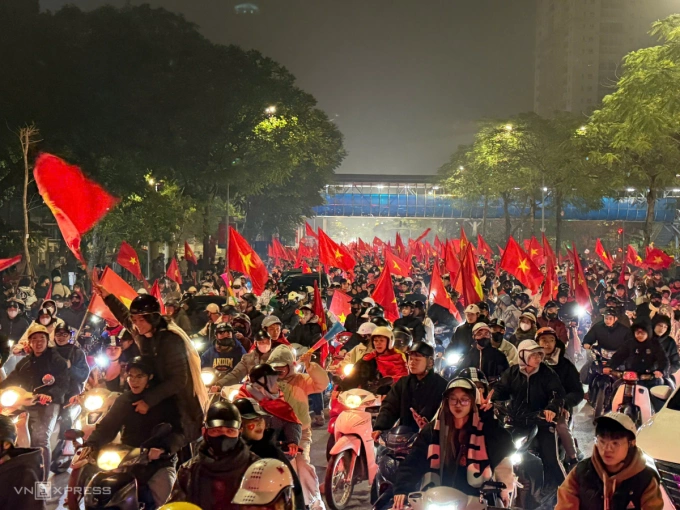 Todo el tramo de la carretera, varios cientos de metros que conducen al túnel Kim Lien, está bañado por el brillo rojo de los faros y las banderas, mientras vítores y gritos llenaban la calle. Foto de Huy Manh