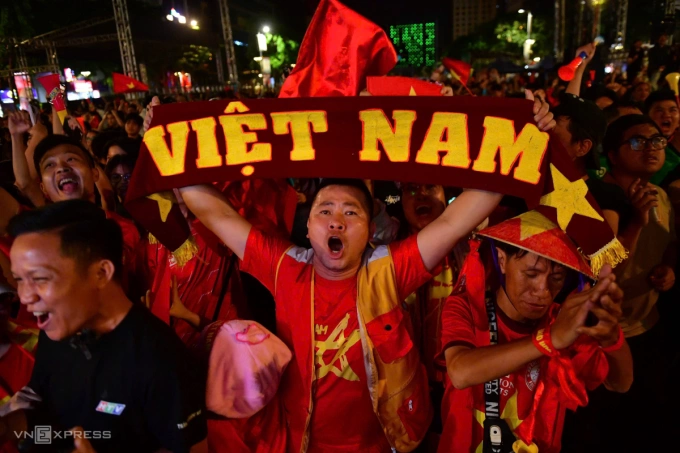 Un aficionado levanta una pancarta de Vietnam en la calle Nguyen Hue para celebrar la victoria. Foto de Thanh Tung