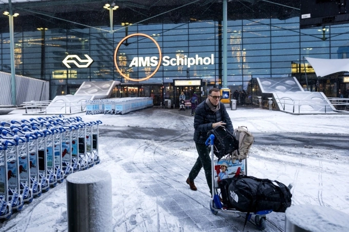 A traveller pushes a cart in front of an entrance at Amsterdam Schiphol airport on Jan. 7, 2026. Photo by AFP
