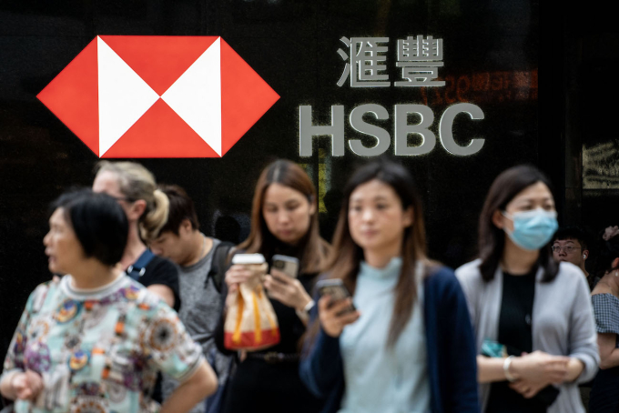 People are crossing the road in front of an HSBC sign in Hong Kong, on April 30, 2024. Photo by NurPhoto via AFP