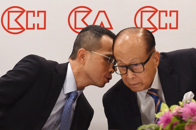 Hong Kongs richest man Li Ka-shing (R), listens to his son Victor during a press conference in Hong Kong on March 16, 2018. Photo by AFP