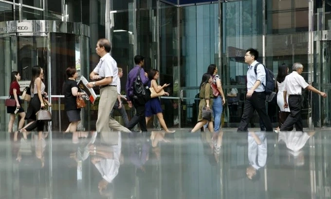 Office workers walk to work during morning peak hour commute in the central business district in Singapore, March 24, 2016. Photo by Reuters