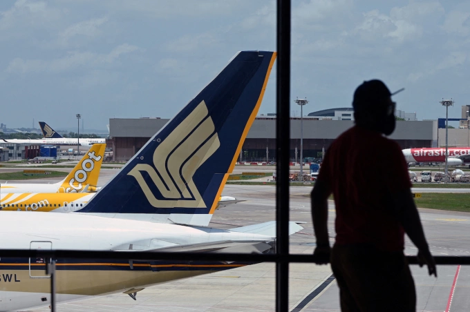 A Singapore Airlines plane is parked besides a Scoot passenger plane on the terminal tarmac at Singapore Changi Airport in Singapore on March 15, 2021. Photo by AFP