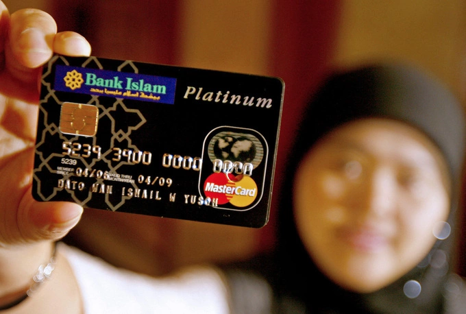A person holds up a credit card in Kuala Lumpur, Malaysia. Photo by AFP