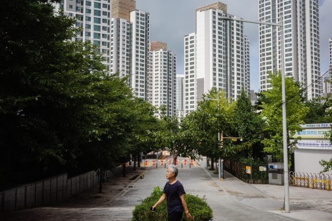 A man walks past blocks of residential buildings in Seoul on August 26, 2025. Photo by AFP