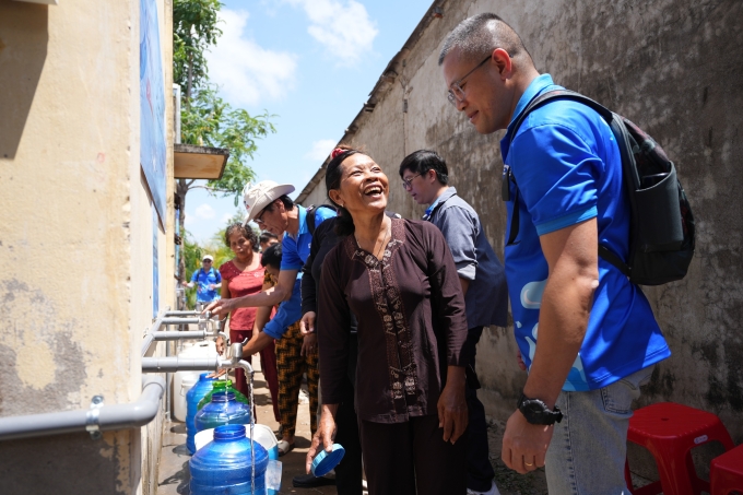 Keppel volunteers are helping the local residents of Khanh Hoa Ward take water from the water filtration system. Photo courtesy of Keppel
