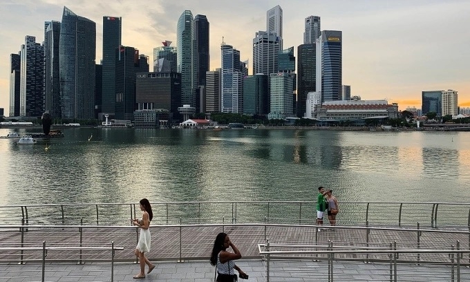 Passers-by hold their mobile phones as people take a selfie photo using a smartphone, with Singapores central business district skyline, in Singapore, May 10, 2019. Photo by Reuters