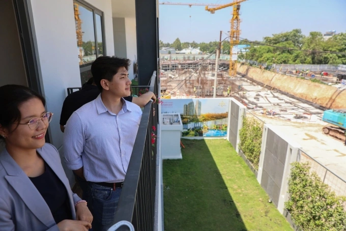 Anh Duy (2nd, L), a customer, observes the project site from the show gallery. Photo by VnExpress/Quynh Tran