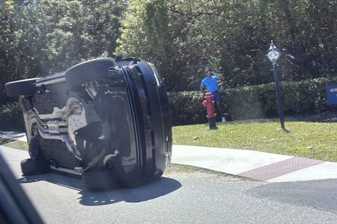 Golfer Tiger Woods stands by his overturned vehicle in Jupiter Island, Fla., on Friday, March 27, 2026. Photo by AP