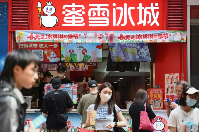 People walk past a Mixue Ice Cream & Tea store in Hong Kong on March 26, 2025. Photo by AFP