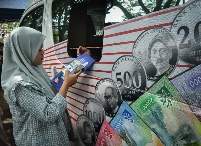 A resident exchanges small change Rupiah at Bank Indonesias mobile banking unit in a city park in Malang, East Java, Indonesia, on February 19, 2026. Photo by NurPhoto via AFP