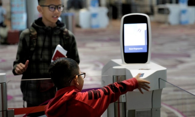 A passenger scans his fingerprint at an automated immigration control gate at Changi airports Terminal 4 in Singapore April 30, 2018. Photo by Reuters