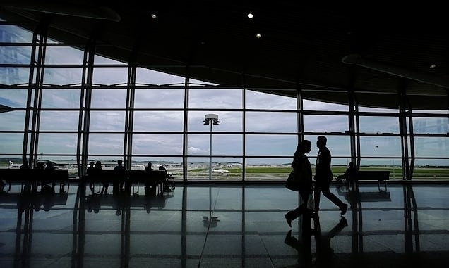 2014 年 6 月 14 日,在吉隆坡郊外的吉隆坡国际机场,乘客们沿着走廊行走时的剪影。照片由路透社提供