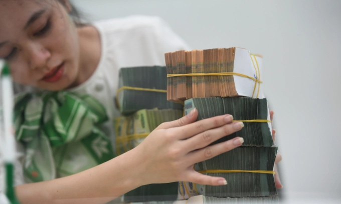 An employee counts Vietnamese banknotes at a bank. Photo by VnExpress/Thanh Tung