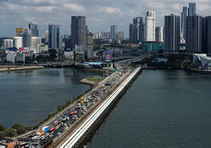 Commuters take the Woodlands Causeway to Singapore from Johor a day before Malaysia imposes a lockdown on travel due to the coronavirus outbreak in Singapore in 2020. Photo by Reuters