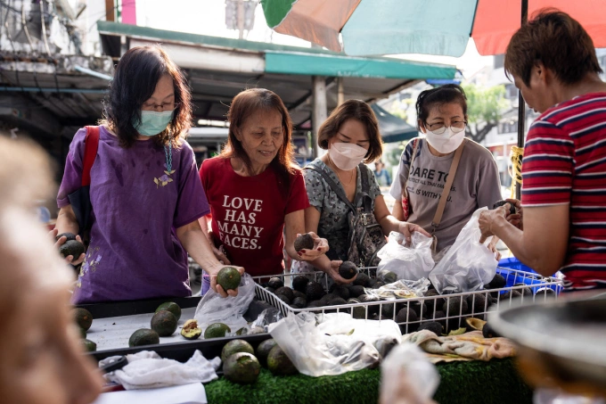 Customers browse avocados at a morning wet market in Bangkok, Thailand, on October 19, 2025. Photo by NurPhoto via AFP