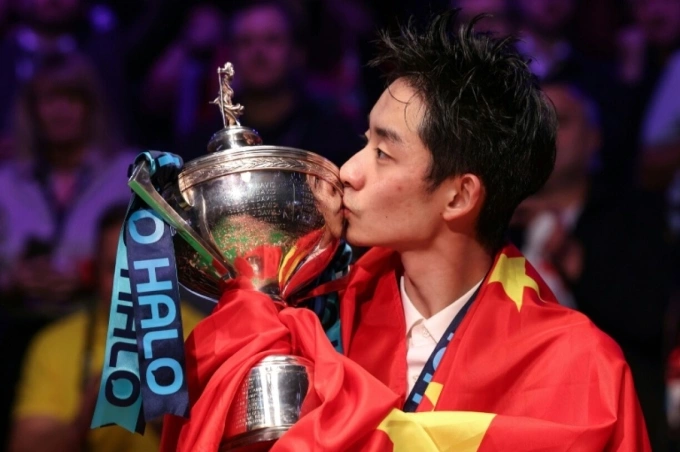 Wu Yize kisses his World Snooker Championship trophy after the final on May 4, 2026. Photo by AFP