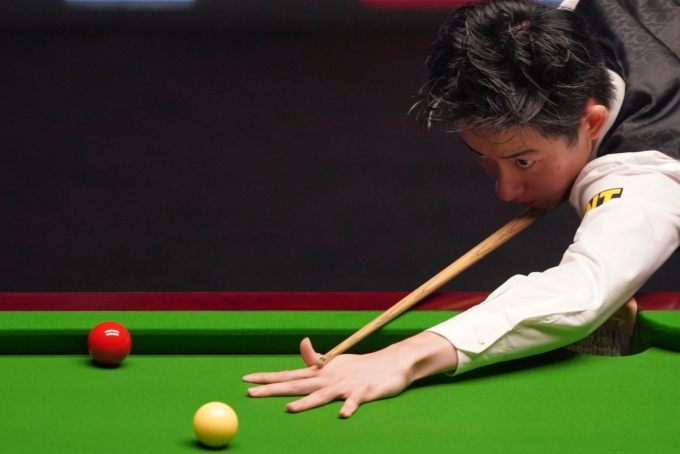 Wu Yize prepares to strike during the 2026 World Snooker Championship final in Sheffield. Photo by AP