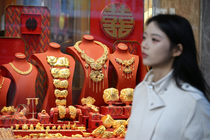 A woman walks past a shop selling gold in Hong Kong on January 26, 2026. Photo by AFP