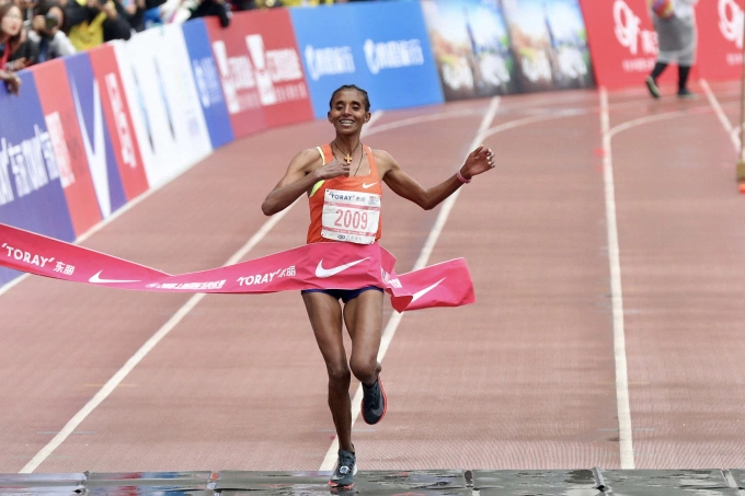 Ethiopian runner Yebrgual Melese celebrates after finishing first at the Shanghai Marathon on Nov. 18, 2018, in Shanghai, China. Photo by AFP