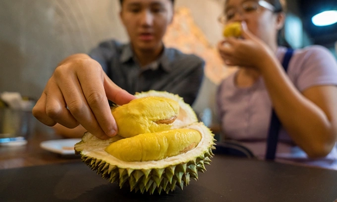 Singapore’s Fairprice Xtra to launch $66 all-you-can-eat durian buffet featuring Musang King, Black Thorn 2 A customer reaches for a durian pulp at a shop in Singapore. Photo by AFP
