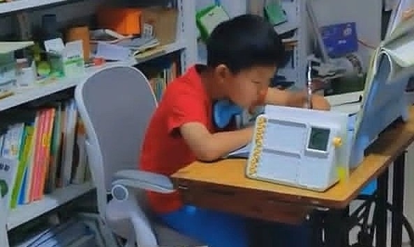 Chinese student does homework while pedaling sewing machine for focus