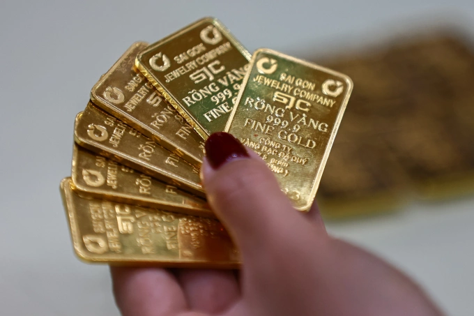 Gold prices extend morning drop 2 A person holds gold bars at a store in Ho Chi Minh City. Photo by VnExpress/Quynh Tran