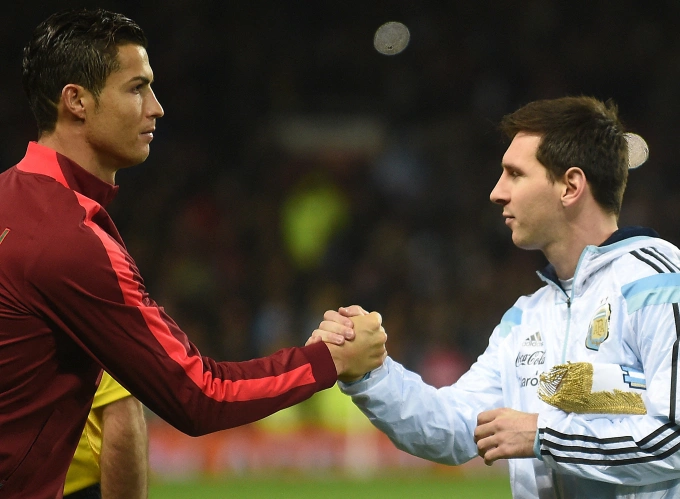 Lionel Messi (R) shakes hands with Cristiano Ronaldo before the friendly match between Argentina and Portugal at Old Trafford, Manchester, England, on Nov. 18, 2014. Photo by AFP