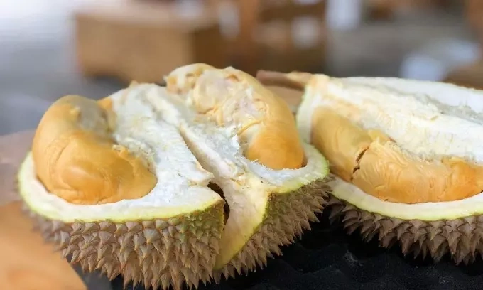 An opened durian seen on a table. Photo by Unsplash/Jim Teo