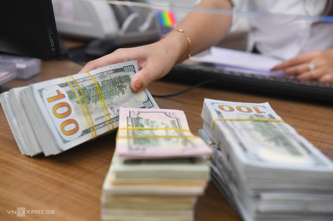 An employee counts U.S. banknotes at a bank in Hanoi. Photo by VnExpress/Giang Huy