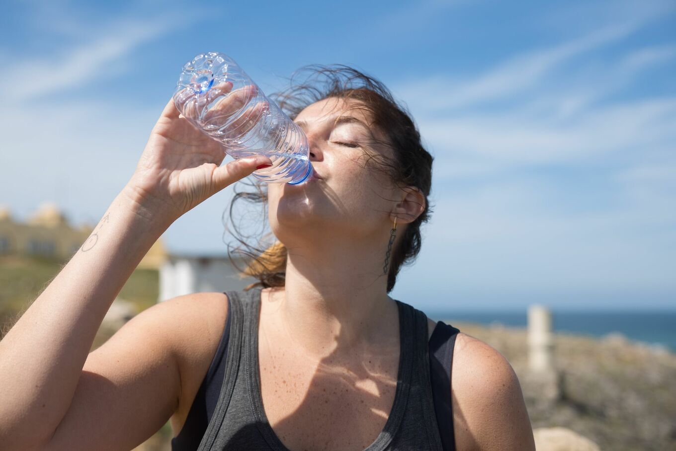 A person drinks water from a bottle. Illustration from Pexels