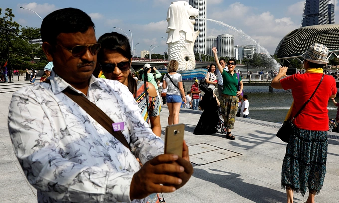 Tourists take photos at the Merlion Park in Singapore January 11, 2017. Photo by Reuters