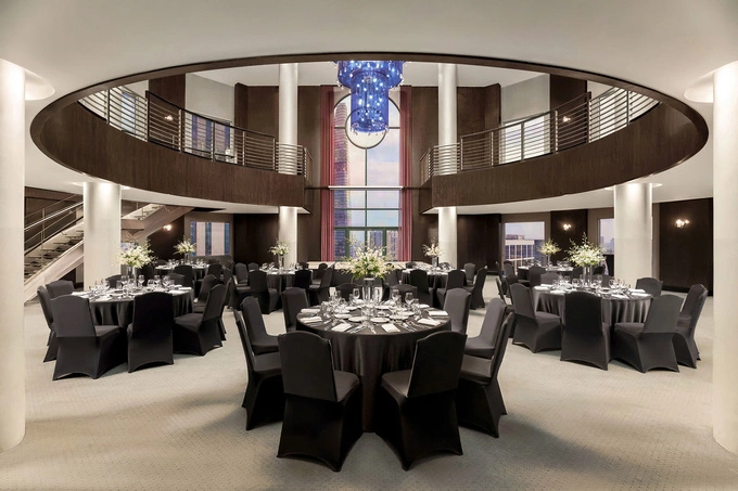 Altitude 23 is a double-height circular atrium extending across two levels, with a sculptural chandelier suspended through the central opening. Photo courtesy of the hotel