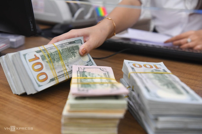 Dollar slides against dong on black market 1 An employee counts U.S. banknotes at a bank in Hanoi. Photo by VnExpress/Giang Huy