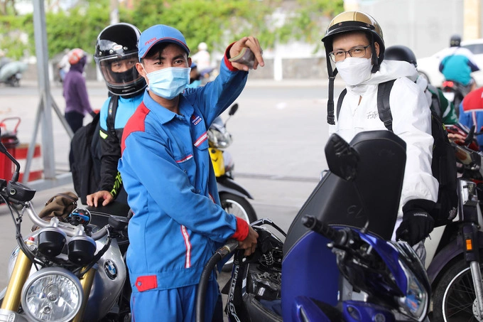 An employee refills a motorbike at a fuel station in HCMC. Photo by VnExpress/Quynh Tran