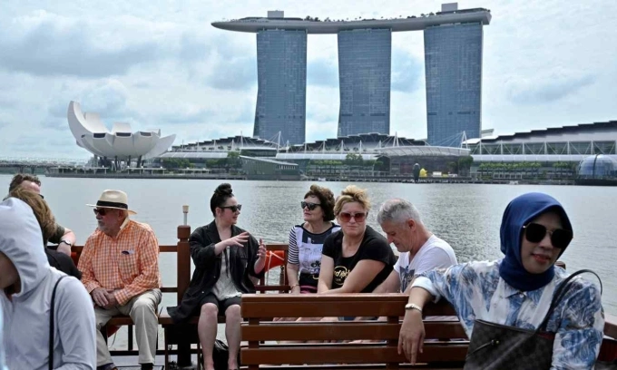 Tourists pose for photos at Marina Bay in Singapore. Photo by Reuters