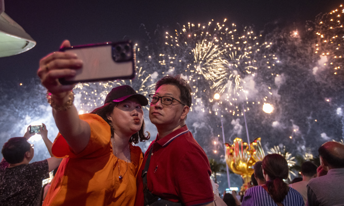 A couple takes a selfie with Fireworks exploding over Victoria Harbour during the China National Day Fireworks Display on October 1, 2023 in Hong Kong, China. Photo by NurPhoto via AFP