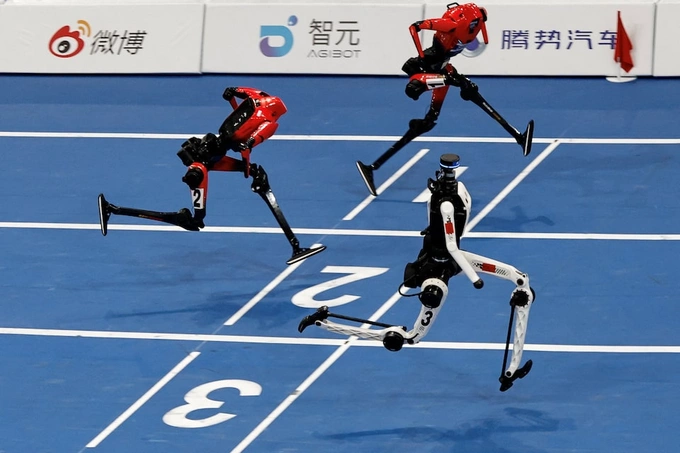 A Tiangong Ultra humanoid robot crosses the finish line in 8.86 seconds, next to Honor humanoid robots, during a 100m large-size group semifinal race, at the 2026 World Humanoid Robot Games at the National Speed Skating Oval in Beijing, China, August 25, 2026. Photo from Reuters