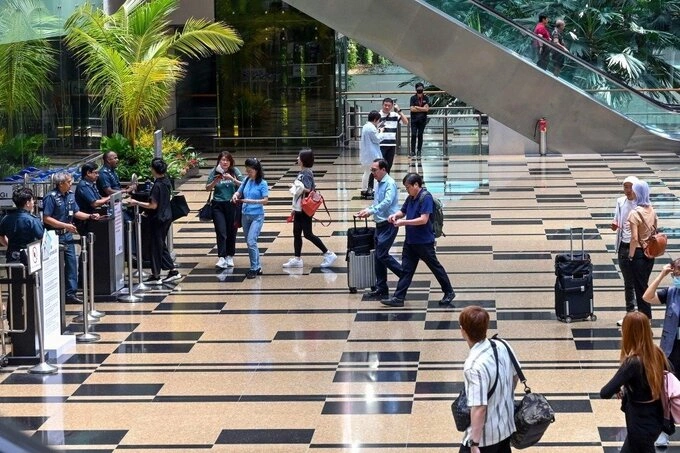 People walk at Changi Airport in Singapore. Photo by AFP