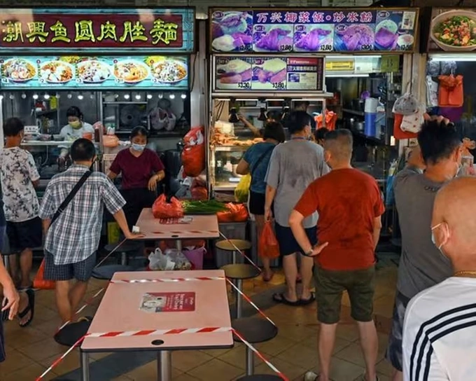 People queue at a hawker centre in Singapore on May 16, 2021. Photo by AFP